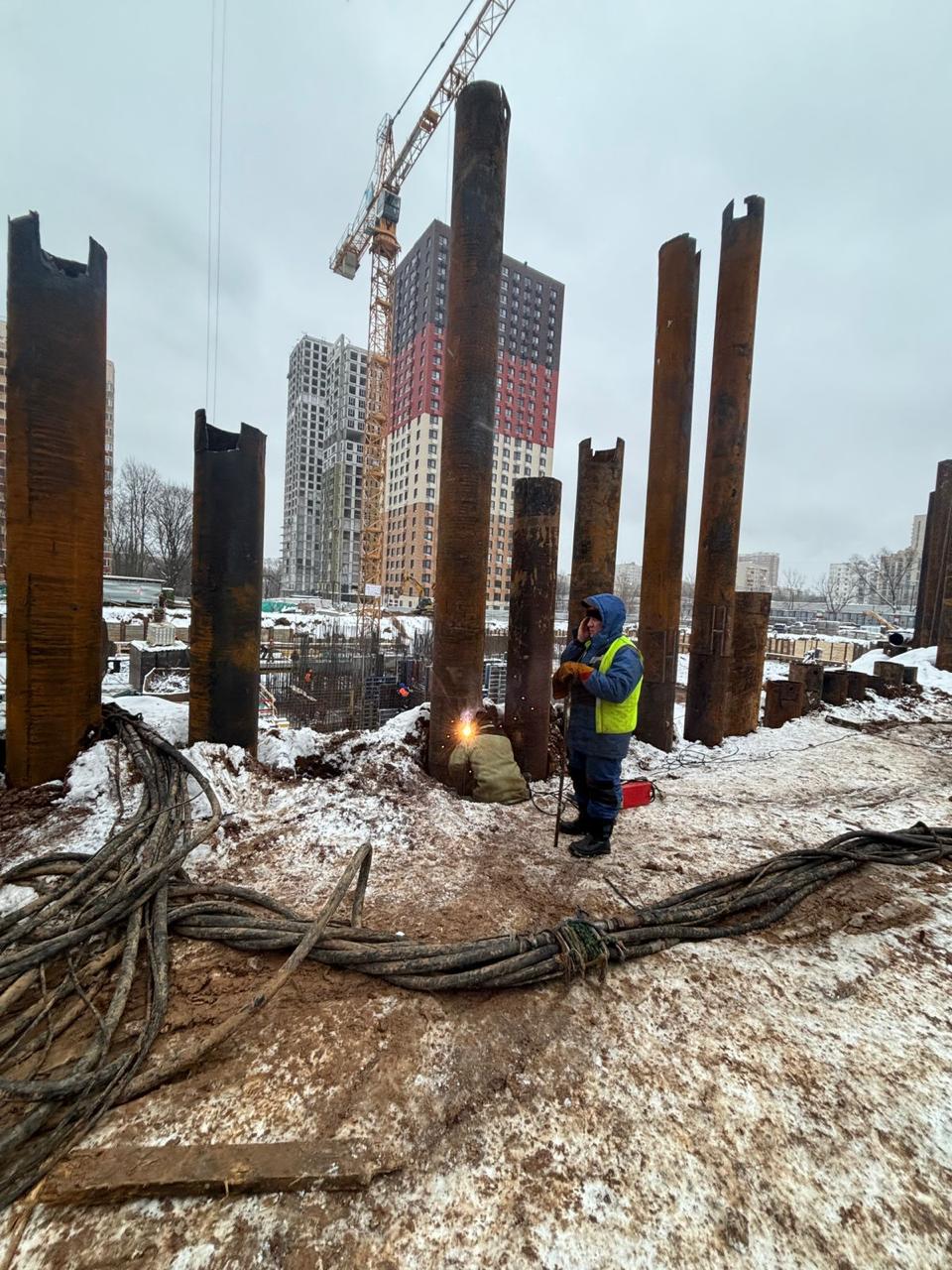 Погружение стальных труб на строительном объекте зимой